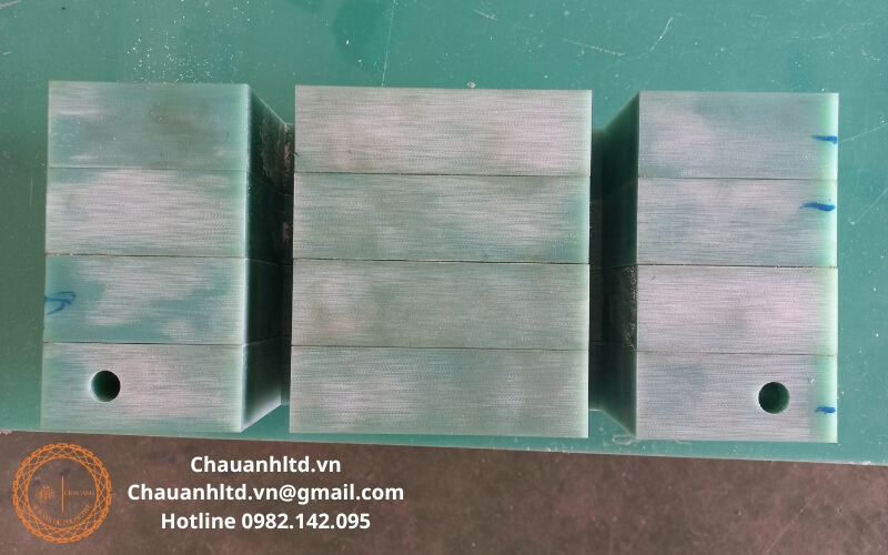 Cận cảnh bề mặt tấm nhựa FR4 cho thấy kết cấu sợi thủy tinh màu xanh ngọc đặc trưng